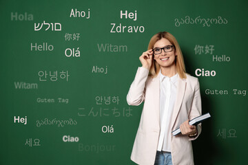 Portrait of happy translator and greeting words in different foreign languages on green background