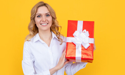 smiling woman hold big present box on yellow background