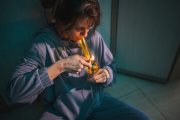 Woman smoking pot using bong