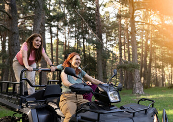Fototapeta na wymiar three mature women on quad bikes driving in nature, enjoying the trip happy feeling free