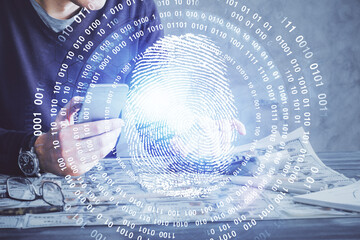 Double exposure of man's hands holding and using a digital device and fingerprint hologram drawing. Security concept.