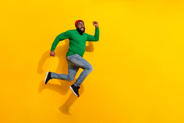 Plakat Photo of sporty energetic active guy jump rush side empty space wear red beanie green shirt isolated yellow color background