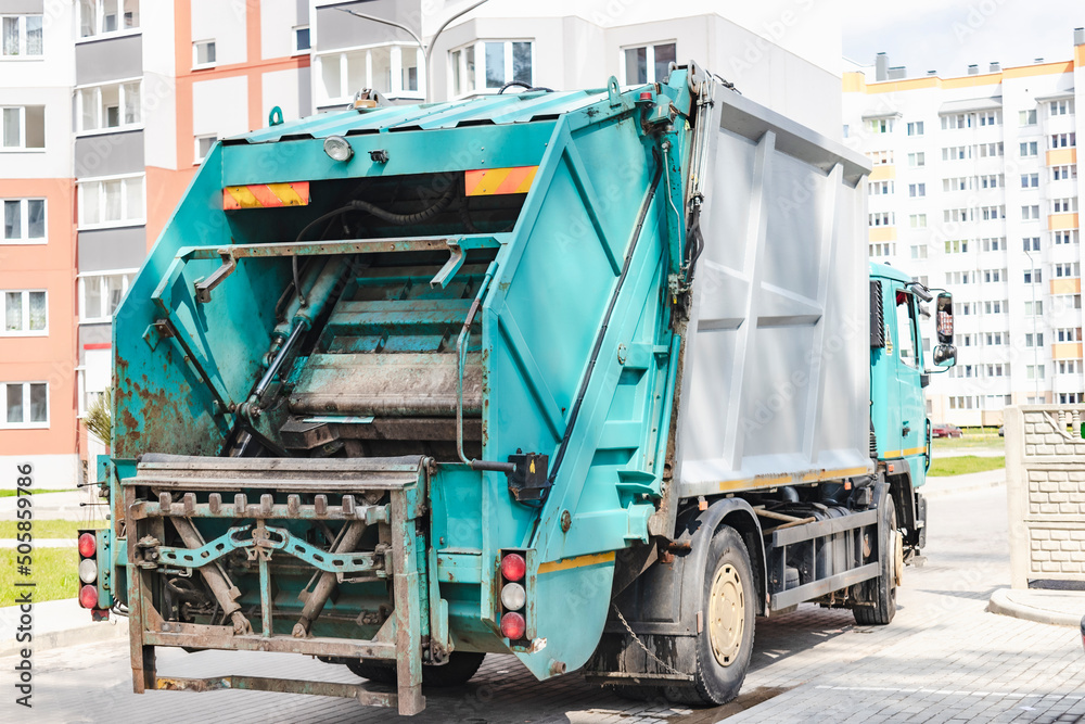 Poster A garbage truck picks up garbage in a residential area. Loading mussar in containers into the car. Separate collection and disposal of garbage. Garbage collection vehicle.