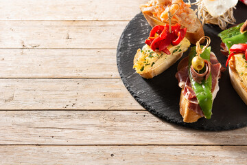 Assortment of Spanish pintxos on wooden table. Typical spanish food Copy space