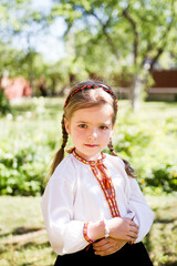 portrait of a little girl.  Little girl in a traditional Ukrainian embroidered shirt. Ukrainian children. Child in the garden.