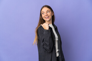 Young Lithuanian woman isolated on purple background pointing to the side to present a product