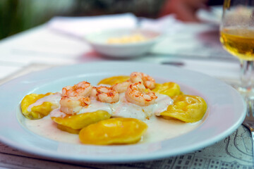 close-up of a plate of sorrentinos with shrimps, Italian food.