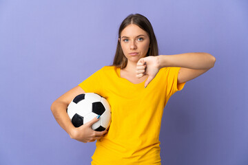 Young Lithuanian football player woman isolated on purple background showing thumb down with negative expression