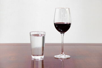 Wine and water, water and wine side by side on the rustic wooden table