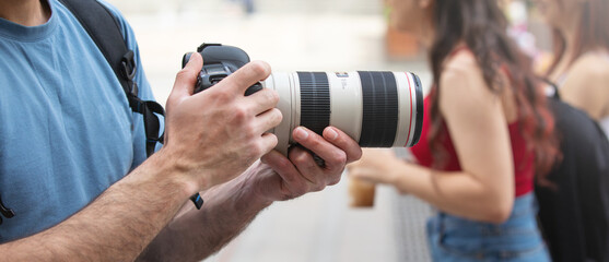 Fototapeta premium Photographer takes photographs with dslr camera in a city.