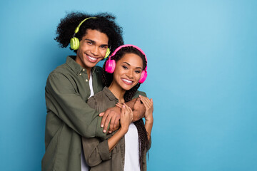 Photo of two cool spouses guy hug lady listen affectionate sound headset wear stylish shirt isolated blue color background - obrazy, fototapety, plakaty