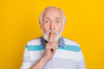 Portrait of attractive worried suspicious grey haired man showing shh sign symbol isolated over...