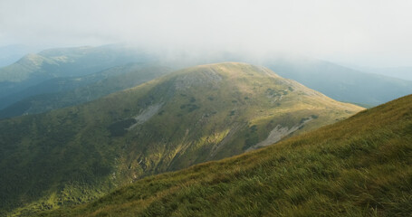 View of the mountains in thick clouds. Fog after the rain. Mountain weather. Carpathians, Ukraine, Europe.