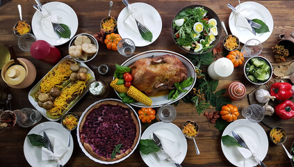 the table is festively set for the Thanksgiving holiday. turkey and seasonal vegetables