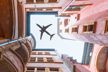 A passenger plane flying top of the houses - Bottom view of typical lyon historic buildings -...
