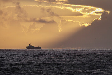 Ship on the horizon at orange sunset