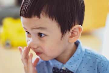 baby picking nose. little baby boy with finger in his nose. Cute little baby boy picking his nose, close up. children's behavior. Selective Focus. - obrazy, fototapety, plakaty