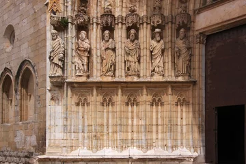 Foto op Plexiglas Gothic archivolt with lancet arches and sculptures of saints at the portal jamb of Castello d’Empuries city church, Catalonia in Spain © float