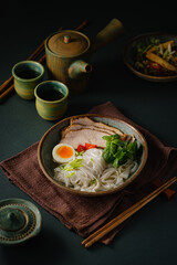 Asian noodle soup on table, ramen with pork, vegetables and egg in a bowl. Copy space - 505879997
