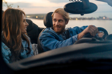 White happy couple smiling and talking during car trip