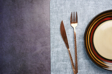 cutlery and empty plate on a black background with copy space 