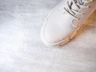 Water droplets on winter shoe protected with waterproof spray  - obrazy, fototapety, plakaty