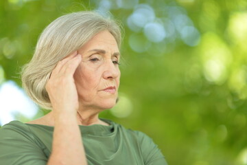 sad senior beautiful woman in park