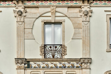 frieze of azulejos, art nouveau tiles and statue on the facade of an old pharmacy in Leiria, Portugal