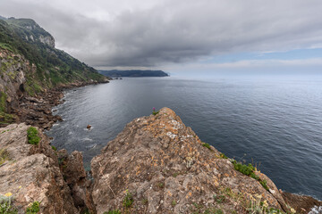 Sample of geology of Iberian North coast: limestone interspersed with karst rocks, covered with sparse vegetation. Spanish Coast of Bay of Biscay, Cabo de Santa Catalina, Lequeitio, Basque Country