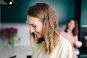 Portrait of a blonde woman who stands in the kitchen and cooks breakfast with her beloved