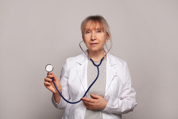 Senior female doctor. Woman medical worker physician holding stethoscope. Medical concept