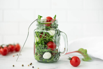 salad with mozzarella, arugula and cherry tomatoes in a glass mug