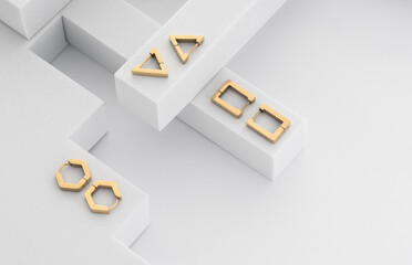 Top view of golden geometric shapes earrings on white background with copy space