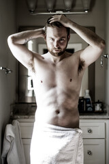 Obraz premium Athletic man wearing towel in the bathroom sunlight