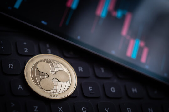 Ripple cryptocurrency coin with candle stick graph chart, laptop keyboard, and digital background