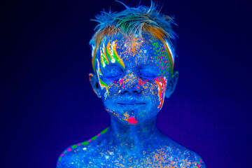 Portrait of a neon child boy posing in UV