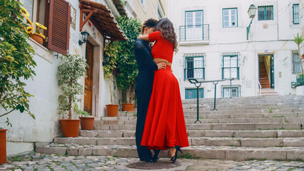 Fototapeta na wymiar Beautiful Couple Dancing a Latin Dance on the Quiet Street of an Old Town in a City. Sensual Dance by Two Professional Dancers on a Sunny Day Outside in Ancient Culturally Rich Tourist Location.