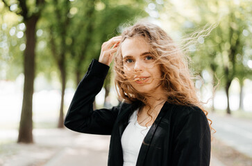 Happy cheerful girl laughs in the park with flowing hair.