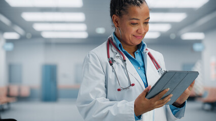 Medical Hospital Portrait: Confident African American Female Medical Doctor Using Digital Tablet...