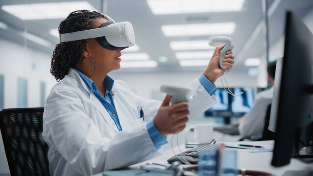 Futuristic Medical Hospital: Neurosurgeon Wearing Virtual Reality Headset Uses Controllers to Remotely Operate Patient with Medical Robot. Modern High-Tech Advance in Breakthrough Medical Treatment