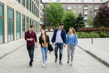 Friendship, travel and vacation concept - group of smiling friends walking in the city