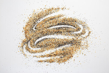 A scattered pile of Everything seasoning containing dried garlic, onion, poppy seeds, sesame seeds and salt on a white background. 