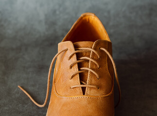 Lacing of comfortablel luxury leather shoe or boot on grey background.