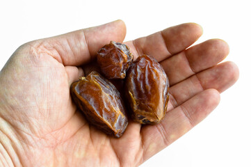 Organic fresh nutritious dried hurma dates medjool grains, on hand - obrazy, fototapety, plakaty