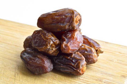 Organic fresh nutritious dried hurma dates medjool grains, on cutting board