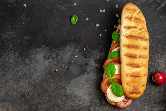 Pressed and toasted panini caprese with tomato, mozzarella and basil, Caprese Panini Sandwich. Delicious breakfast or snack, Clean eating, dieting, vegan food concept. top view