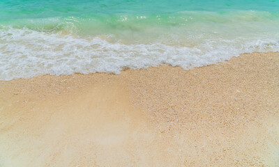 Fototapeta na wymiar Sand beach seaside with white foamy from blue sea in summer season 