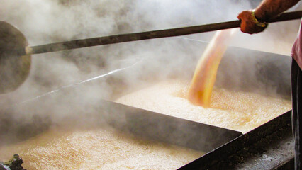 large tacho of boiling molasses the main ingredient of the rapadura, the molasses effervido and mechido trasnferido in variso pachas during the process