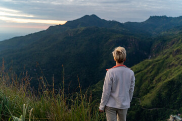 A woman on the top of the mountain at sunrise, Sri Lanka, Little Adam's peak