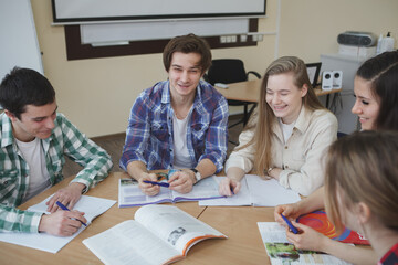 Cheerful young people enjoying studying together, discussing project